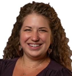 Woman with brown curly hair wearing a dark purple top smiling at the camera. 